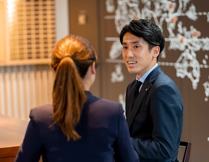 デスクを挟んで打ち合わせをする先輩社員