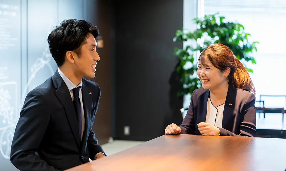 カウンター越しに笑い合う先輩社員と後輩社員