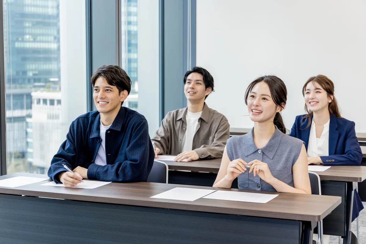 研修会場で講師の話を聞く社員たち