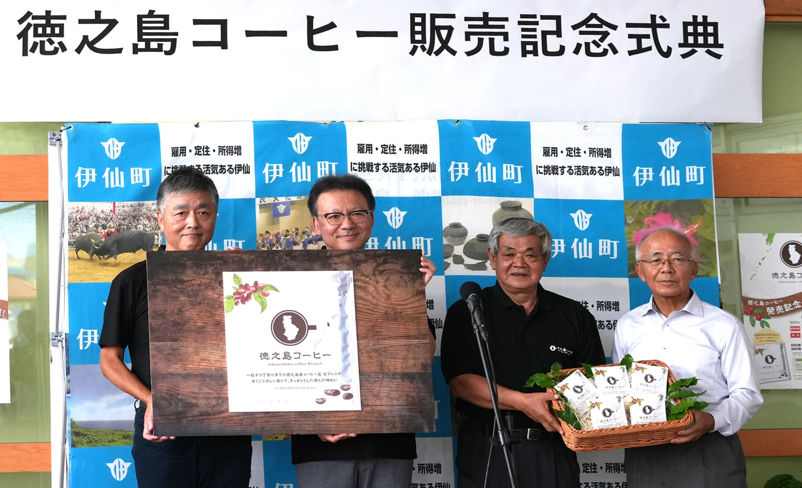 徳之島コーヒー販売記念式典で商品を掲げる関係者